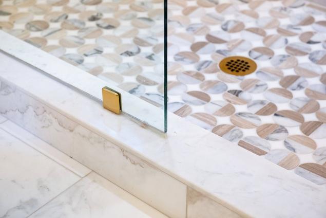 Close-up detail of the primary bathroom's marble shower threshold.